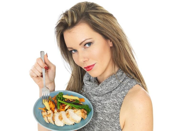 Gadis makan ayam dengan sayur-sayuran untuk menurunkan berat badan